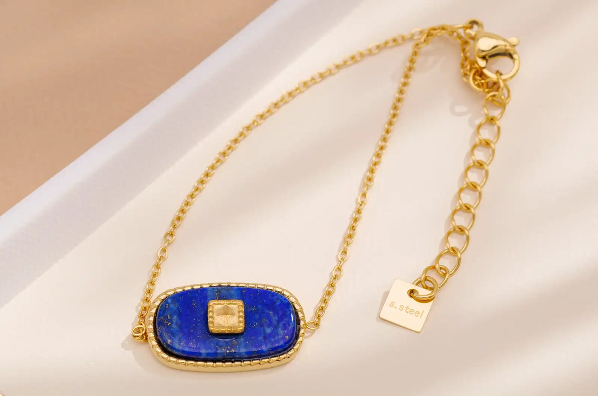 Goldfarbenes Armband mit blauem Stein auf hellem Hintergrund – ruhige Sommer-Eleganz, Avirelle.