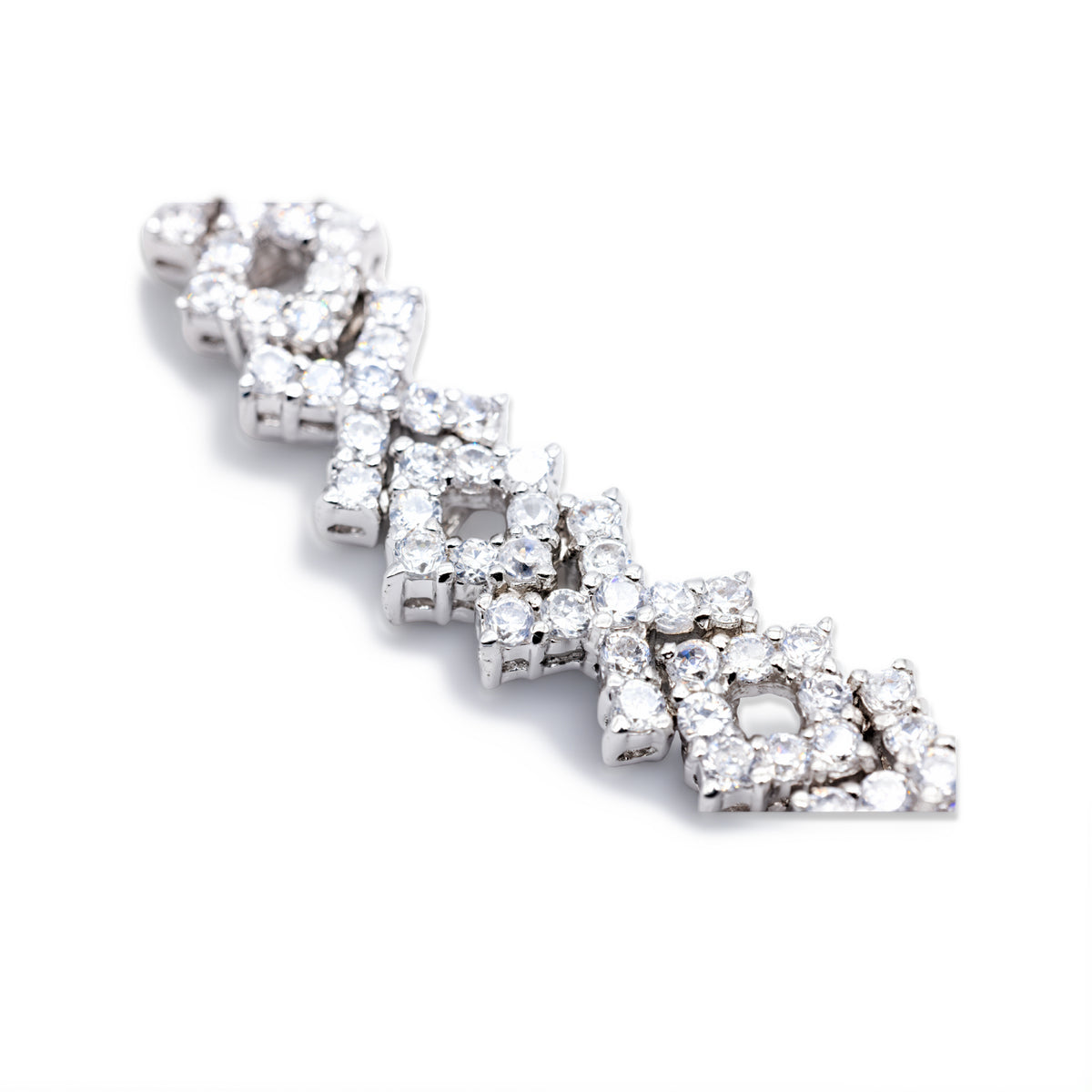 Nahaufnahme des Cluster-Musters eines silberfarbenen Tennisarmbands mit klaren Zirkonia, gefüllte und offene Formen im Detail.